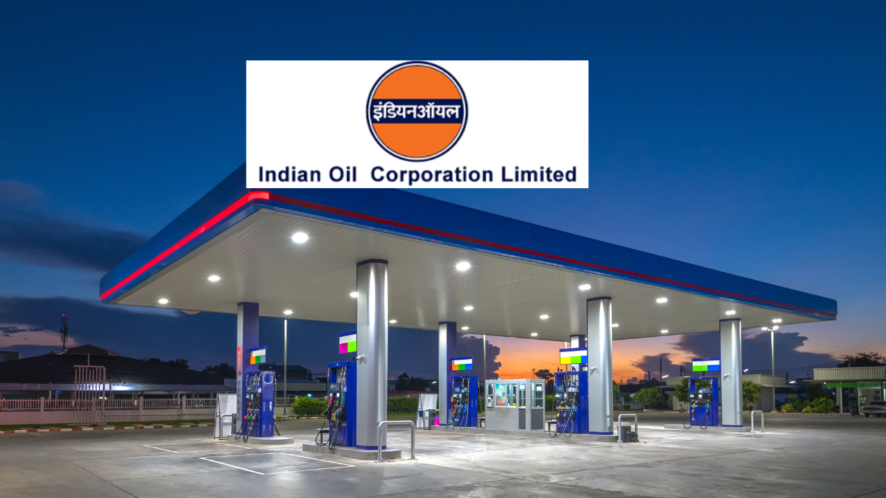 An Indian Oil Corporation Limited fuel station lit up at dusk, with fuel pumps under a canopy and the IOCL logo
