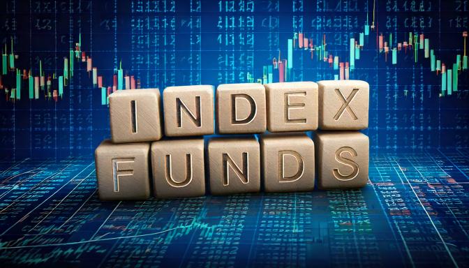 Wooden letter blocks spelling INDEX FUNDS stacked over a blue stock-market candlestick chart background.